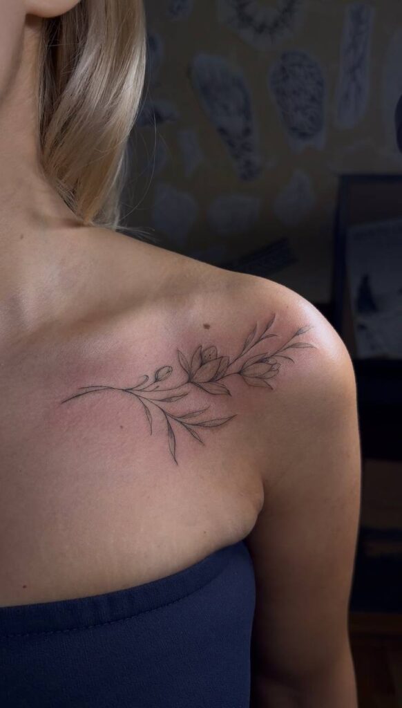 Fine Line Blumenzweig an Schulter und Schlüsselbein