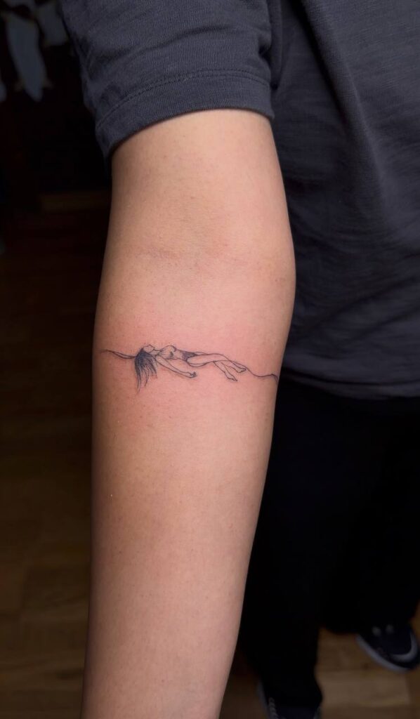 Minimalistisches Fine Line Tattoo am Unterarm: liegende Figur auf einer Linie