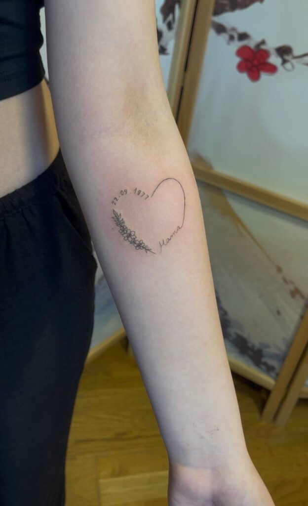 Herz mit Datum, Blüten und Schriftzug „Mama“ am Unterarm