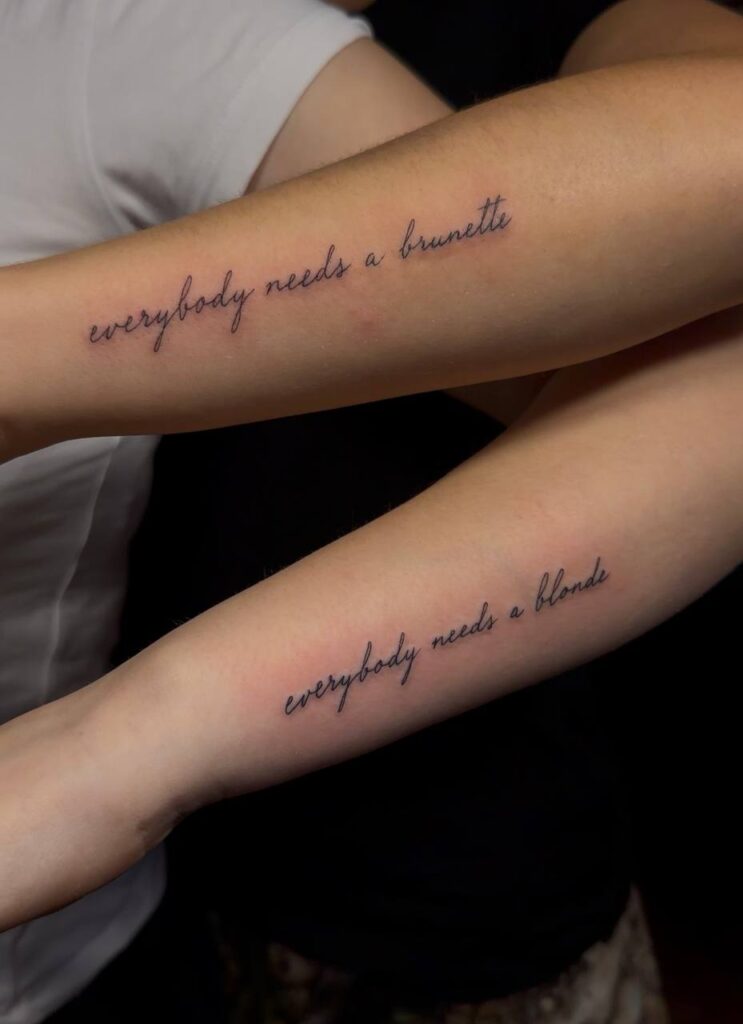Partner-Schriftzüge „everybody needs a brunette“ und „everybody needs a blonde“ am Unterarm